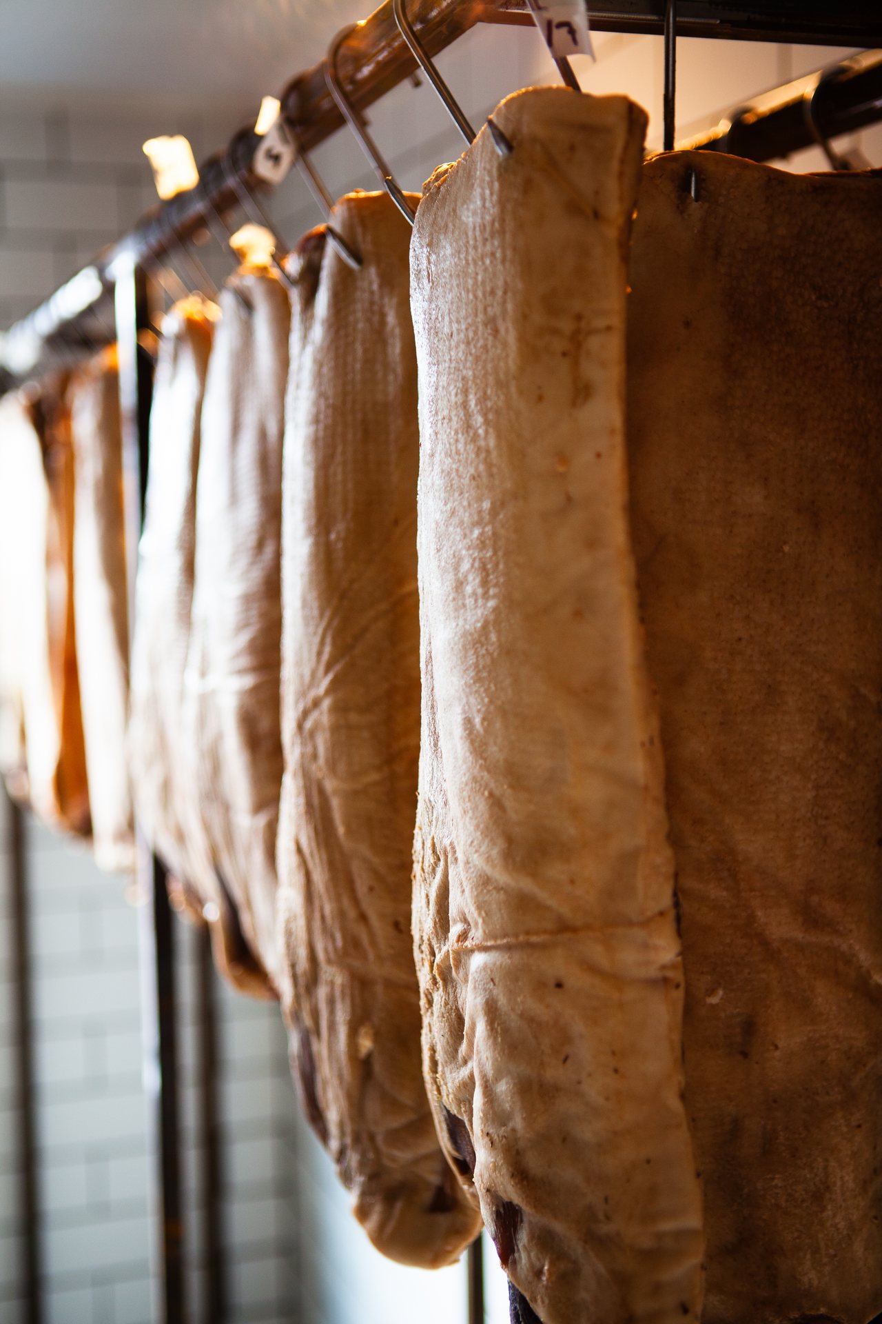 Our own charcuterie hanging to dry in the kitchen
