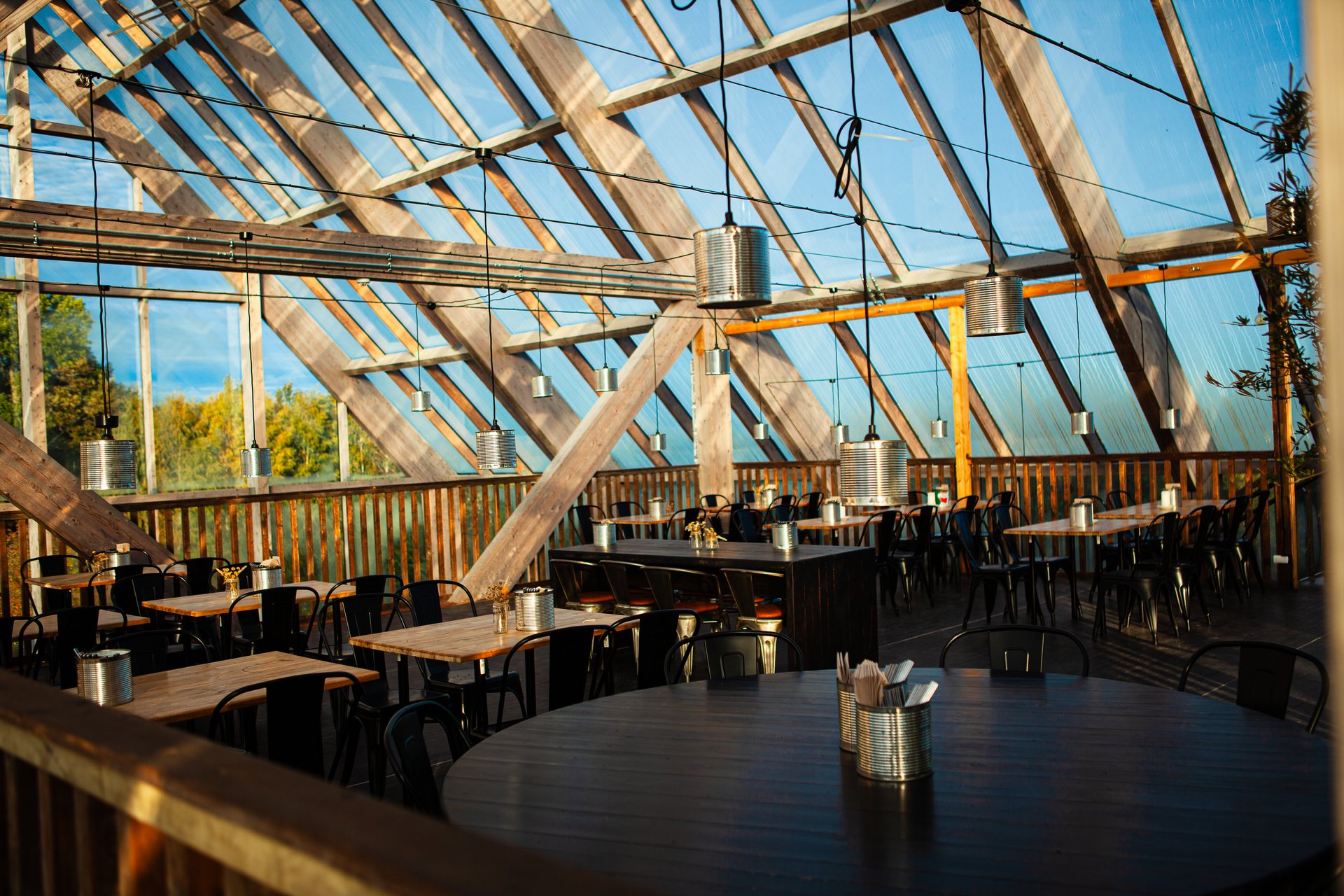 A round table and laid tables under the glass roof in the sunlight